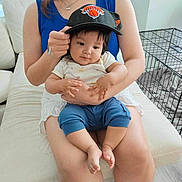 Noah is registered to the contest to win money with this photo: accessories, baby, baseballcap, cap, clothing, couch, face, furniture, hat, head, jeans, jewelry, necklace, pants, people, person, photography, portrait, shorts, sitting