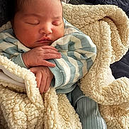 Anylah is registered to the contest to win money with this photo: baby, sleeping, blanket, cozy, striped_clothing, hands, face, infant, soft_texture, warm, cute, rest, comfort, child, portrait, indoors, peaceful, newborn, cuddly, toddler