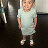 toddler, child, smiling, standing, indoors, dress, sandals, daisy, floor, door, earrings, short_hair, happy, person, young_child, portrait, cute, feet, clothing, home