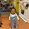 adult, chair, child, daycare, denim, flooring, flowers, furniture, happy, indoor, kid, overalls, person, photography, playroom, smiling, toddler, walking, wall_art, yellow_wall