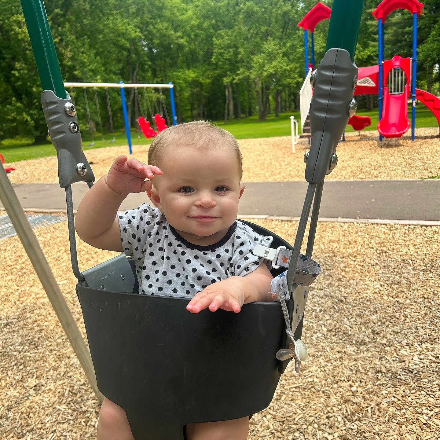 Amelia is registered to the contest to win money with this photo: baby, blue_swing, child, daytime, fun, grass, happy, nature, outdoor, park, person, play, playground, polka_dot, red_slide, shirt, smile, swing, trees, woodchips