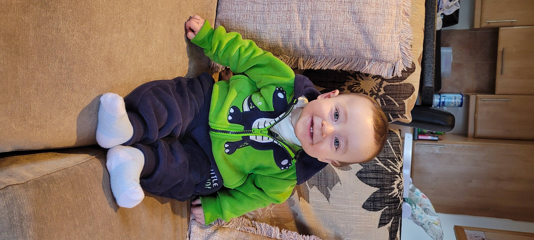 Jake is registered to the contest to win money with this photo: baby, baby_toddler_clothing, cheek, child, comfort, fun, grass, happy, hat, jacket, joy, person, personal_protective_equipment, sitting, sleeve, smile, sock, toddler, tree, windbreaker