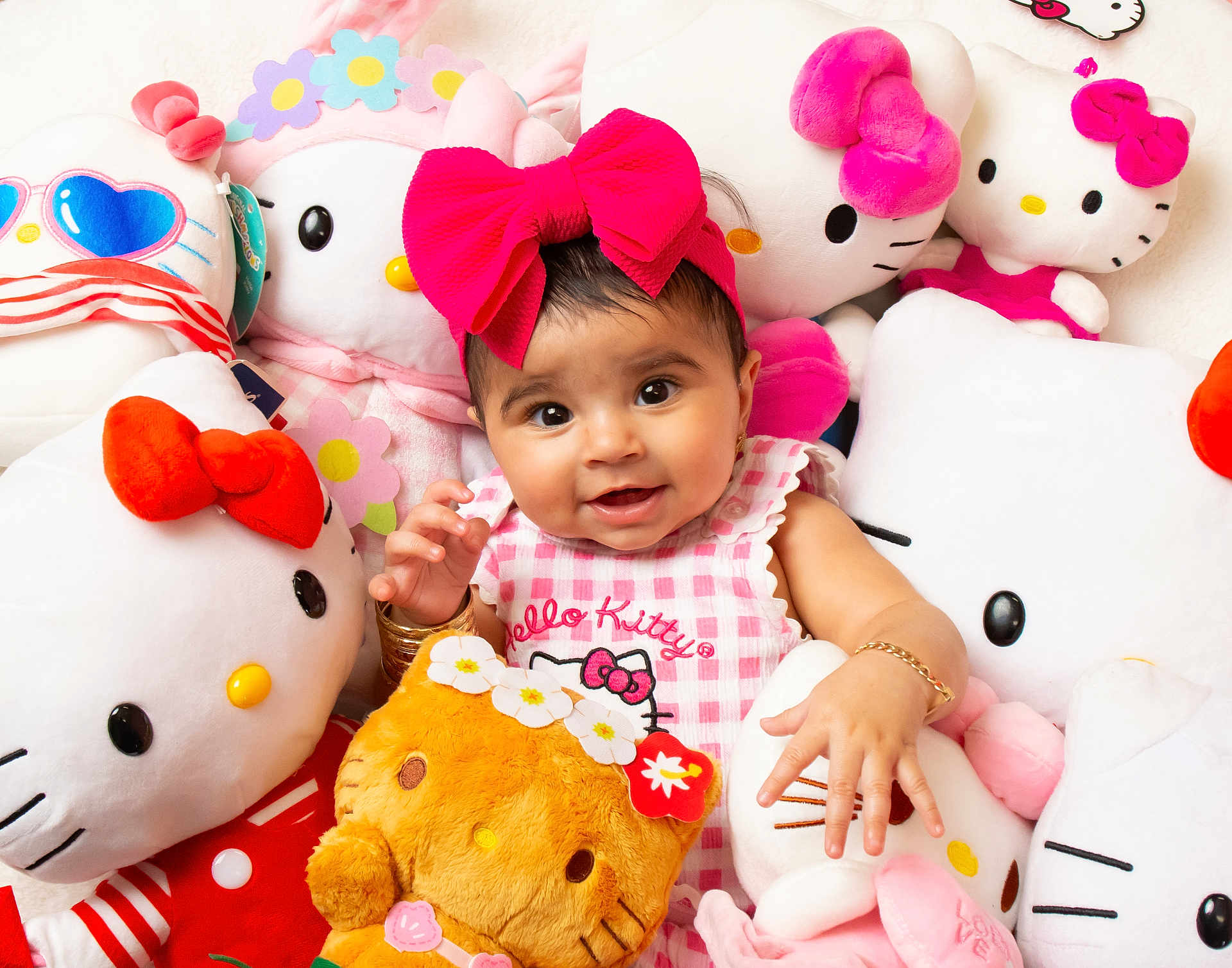 Reynesmae is registered to the contest to win money with this photo: baby, child, girl, pink_bow, hello_kitty, plush_toys, stuffed_animals, smiling, cute, indoor, soft_toys, cuddly, happy, portrait, infant, clothing, bracelet, headwear, toy, playful