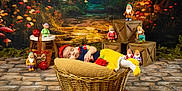 Reynesmae is registered to the contest to win money with this photo: baby, sleeping, basket, knitted_clothing, apples, dwarfs, toys, forest_backdrop, wooden_crates, stone_floor, colorful, cute, child, decor, props, headband, pillow, figurines, still_life, portrait