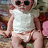 Aïnhoa participe au concours pour gagner de l'argent avec cette photo : accessory, baby, black_socks, child, colorful_background, couch, cute, fashion, hand, hat, holding_hand, indoors, infant, patterned_couch, person, pink_shorts, portrait, sitting, sunglasses, white_shirt