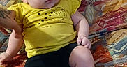 Aïnhoa participe au concours pour gagner de l'argent avec cette photo : baby, black_shorts, casual_clothing, child, chubby_cheeks, colorful, curious, cute, human, indoors, infant, one_person, patterned_blanket, portrait, relaxed, resting, sitting, soft_lighting, yellow_shirt, young_child