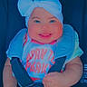 Marleigh is registered to the contest to win money with this photo: baby, child, car_seat, smiling, bow, headwear, infant, happy, portrait, cute, clothing, seatbelt, safety, hands, face, person, young, cheeks, sitting, bright