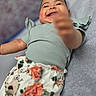 Marleigh joined the competition — help win amazing prizes! baby, child, smiling, reaching, green_top, floral_pants, lying_down, blurred_background, happy, cute, indoor, person, infant, portrait, chubby_cheeks, clothing, fabric, skin, face, hand