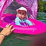 baby, child, float, water, lake, hat, pink, sunhat, summer, outdoor, nature, hand, trees, people, infant, swimming, recreation, watercraft, sunshine, floatation_device