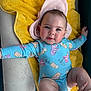 baby, child, infant, towel, hat, blue_clothing, pineapple_pattern, bear_pattern, smiling, cute, skin, face, hand, leg, sitting, indoors, soft_texture, comfort, playful, adorable