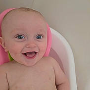 Kingston is registered to the contest to win money with this photo: baby, smile, blue_eyes, bathtub, pink, white, child, happy, skin, water_droplets, infant, cute, person, head, portrait, naked_torso, bath_time, young_child, indoors, close_up