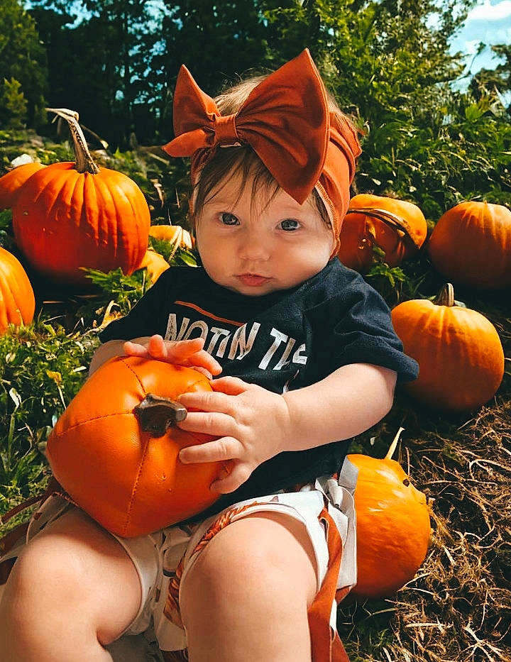 Chloe joined the competition — help win amazing prizes! botany, calabaza, cucurbita, facial_expression, gourd, grass, happy, head, headwear, human_body, natural_foods, nature, orange, person, plant, pumpkin, shorts, squash, toddler, vegetable