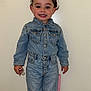 toddler, child, denim_jacket, denim_pants, standing, pigtails, smiling, pacifier, pink_chair, indoor, socks, cute, portrait, happy, young_child, person, clothing, full_body, wall, footwear
