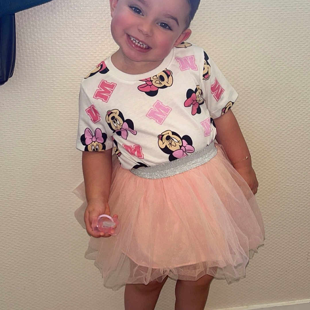 Joy participe au concours pour gagner de l'argent avec cette photo : child, clothing, cute, fashion, floor, happy, indoor, minnie_mouse, person, pink, playful, posing, sandals, shirt, short_hair, smiling, standing, tutu, wall, wooden_floor