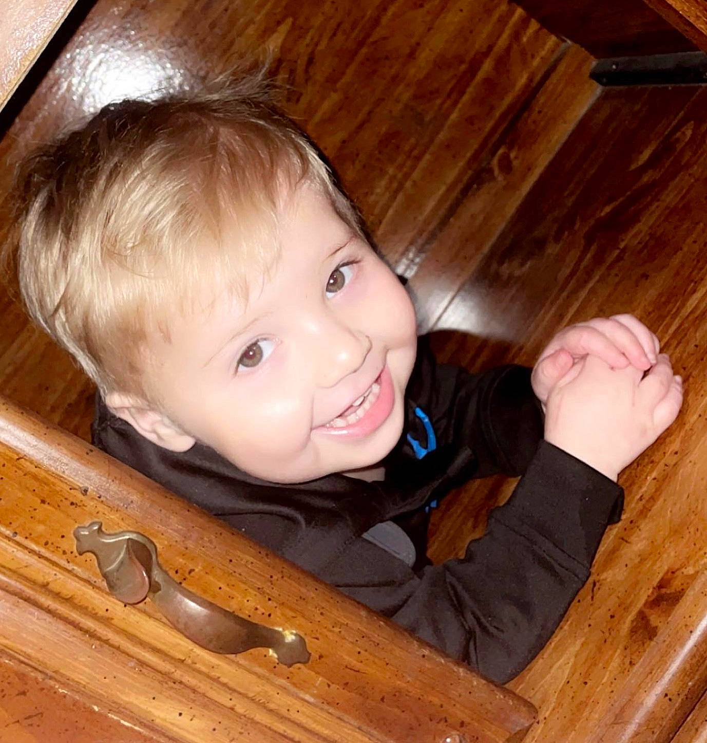 Jamison is registered to the contest to win money with this photo: brown, cheek, chin, eye, finger, fun, hair, hairstyle, happy, hardwood, joy, nose, organ, person, skin, smile, table, thumb, toddler, varnish