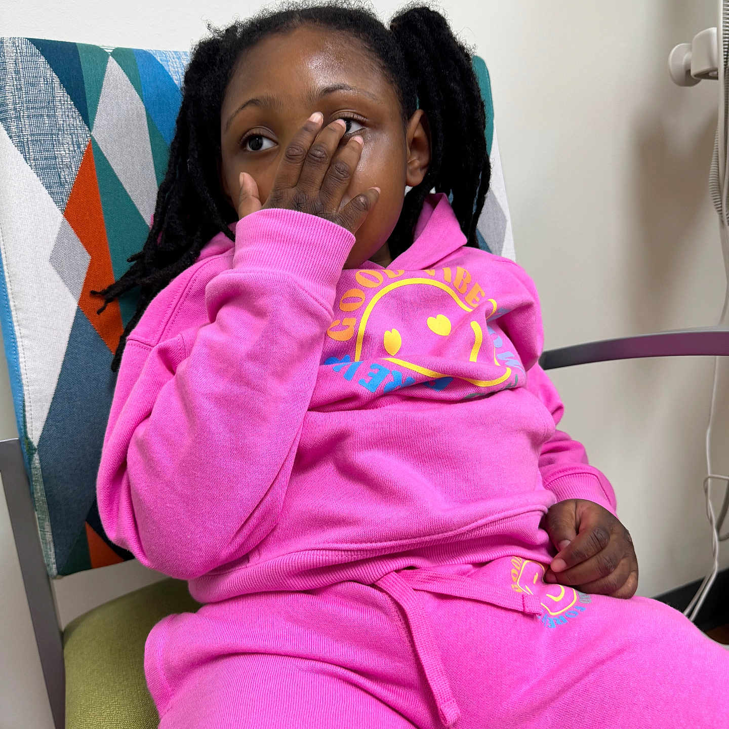 Prayze joined the competition — help win amazing prizes! casual_clothing, chair, child, colorful, comfort, dreadlocks, expression, furniture, geometric_pattern, hand_on_face, home, indoor, modern, person, pink_tracksuit, playful, portrait, relaxed_pose, sitting, young