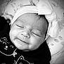 baby, infant, headband, bow, black_and_white, sleeping, face, cute, clothing, pattern, blanket, portrait, closeup, child, smile, resting, young, happy, soft_lighting, indoors