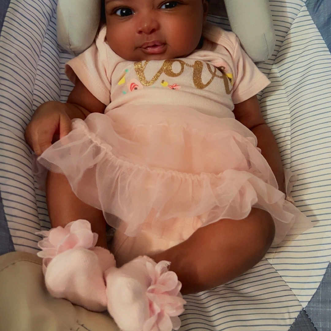 Erielle joined the competition — help win amazing prizes! baby, baby_girl, baby_seat, child, closeup, cushion, cute, flower_accessory, headband, indoor, infant, pink_clothing, portrait, relaxed, small_feet, small_hands, smile, socks, soft_toys, tutu