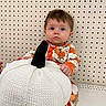 Brielle joined the competition — help win amazing prizes! baby, child, infant, portrait, sitting, wide_eyed, face, eyes, floral_outfit, orange, white_pumpkin, knitted, pumpkin, black_stem, autumn, seasonal, indoor, pegboard, cozy, photography