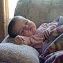 armchair, baby, blanket, child, comfort, cozy, curtains, cute, furniture, home, indoors, nap, peaceful, person, pink_clothing, relaxing, rest, sleeping, soft_light, toddler