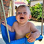 Liam participe au concours pour gagner de l'argent avec cette photo : baby, child, swing, blue_swing, outdoor, sunny, happy, smiling, diaper, playful, face, skin, arm, leg, flower, brick_wall, rope, daylight, garden, person