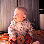 Liam a rejoint le concours — aidez-le/la à gagner de superbes lots ! baby, child, infant, sitting, blue_eyes, orange_blanket, patterned_shirt, rust_pants, milestone_card, indoor, wooden_background, cute, hands, socks, portrait, soft_lighting, curious, cozy, young_child, casual_clothing