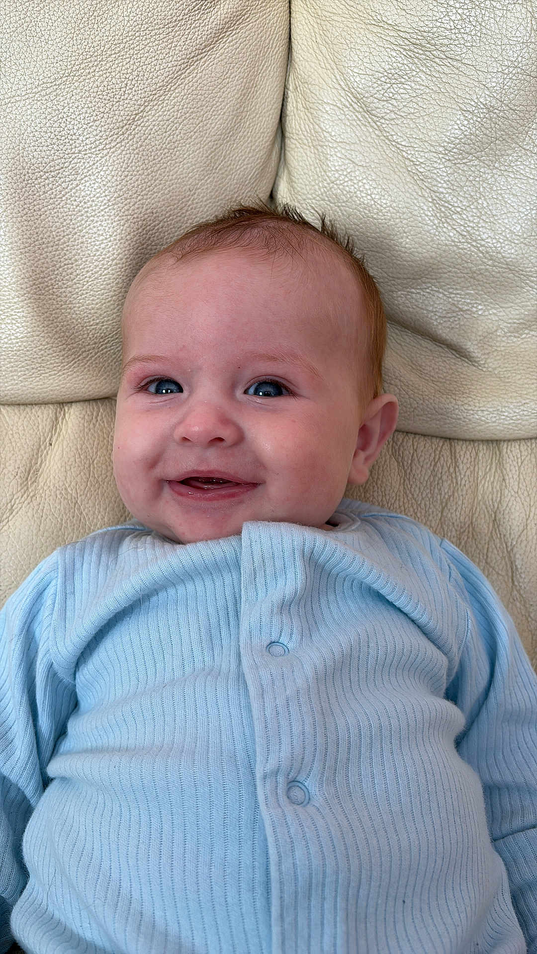 Noah-James joined the competition — help win amazing prizes! baby, smiling, blue_clothing, infant, face, happy, leather_couch, portrait, cute, child, sitting, indoor, buttoned_shirt, young_child, skin, head, eyes, mouth, expression, cozy