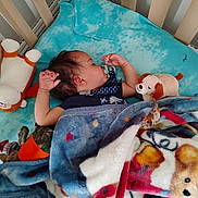 Octavius is registered to the contest to win money with this photo: baby, infant, crib, blanket, plush_toy, stuffed_animal, pacifier, sleeping, nap_time, blue_blanket, crib_bars, soft_toy, pajamas, hand, hair, cozy, nursery, teddy_bear, peaceful, bedding