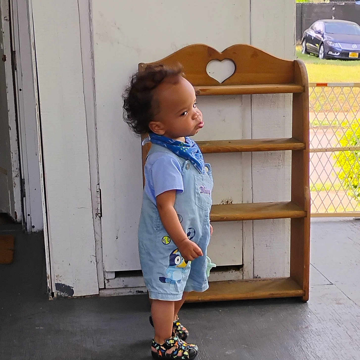 Octavius joined the competition — help win amazing prizes! toddler, child, porch, overalls, blue_bandana, colorful_shoes, wooden_shelf, heart_cutout, car, grass, outdoor, concrete_floor, door, curly_hair, side_profile, standing, casual_clothing, daylight, expression, small_person