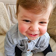 Tommy a rejoint le concours — aidez-le/la à gagner de superbes lots ! baby, child, closeup, couch, cozy, cute, face, furniture, hand, happy, indoor, infant, person, portrait, rosy_cheeks, sitting, smile, sweater, white_shoes, young_child
