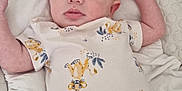 Lucas joined the competition — help win amazing prizes! baby, infant, onesie, baby_nest, padded_bed, lion_cub_print, clothing, cute, lying_down, indoor, soft_texture, face, arms_up, expression, child, newborn, person, comfort, resting, closeup