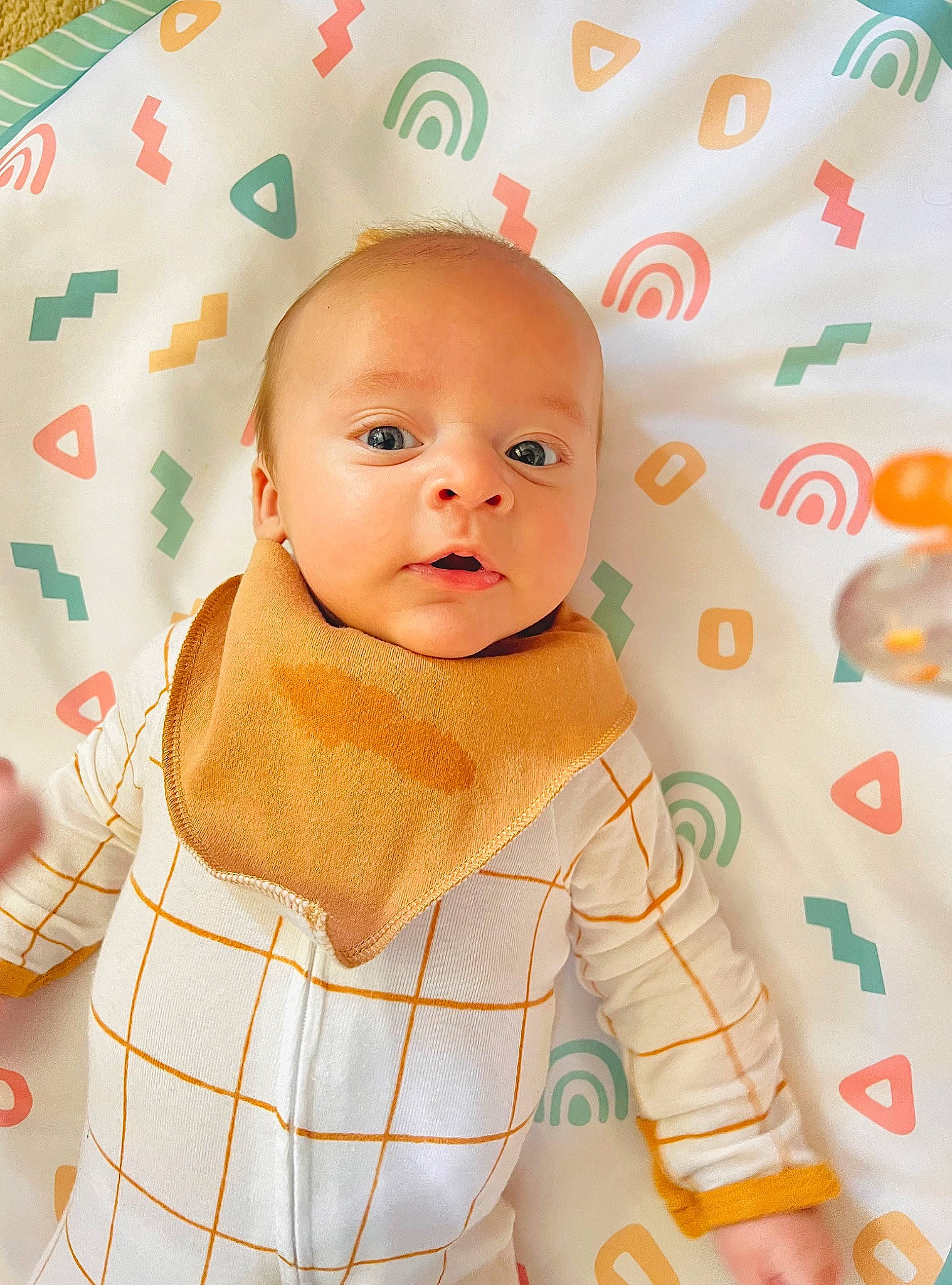 Woods is registered to the contest to win money with this photo: baby, baby_safety, baby_toddler_clothing, cheek, child, chin, collar, comfort, face, facial_expression, happy, head, linens, orange, pattern, person, product, skin, sleeve, toddler