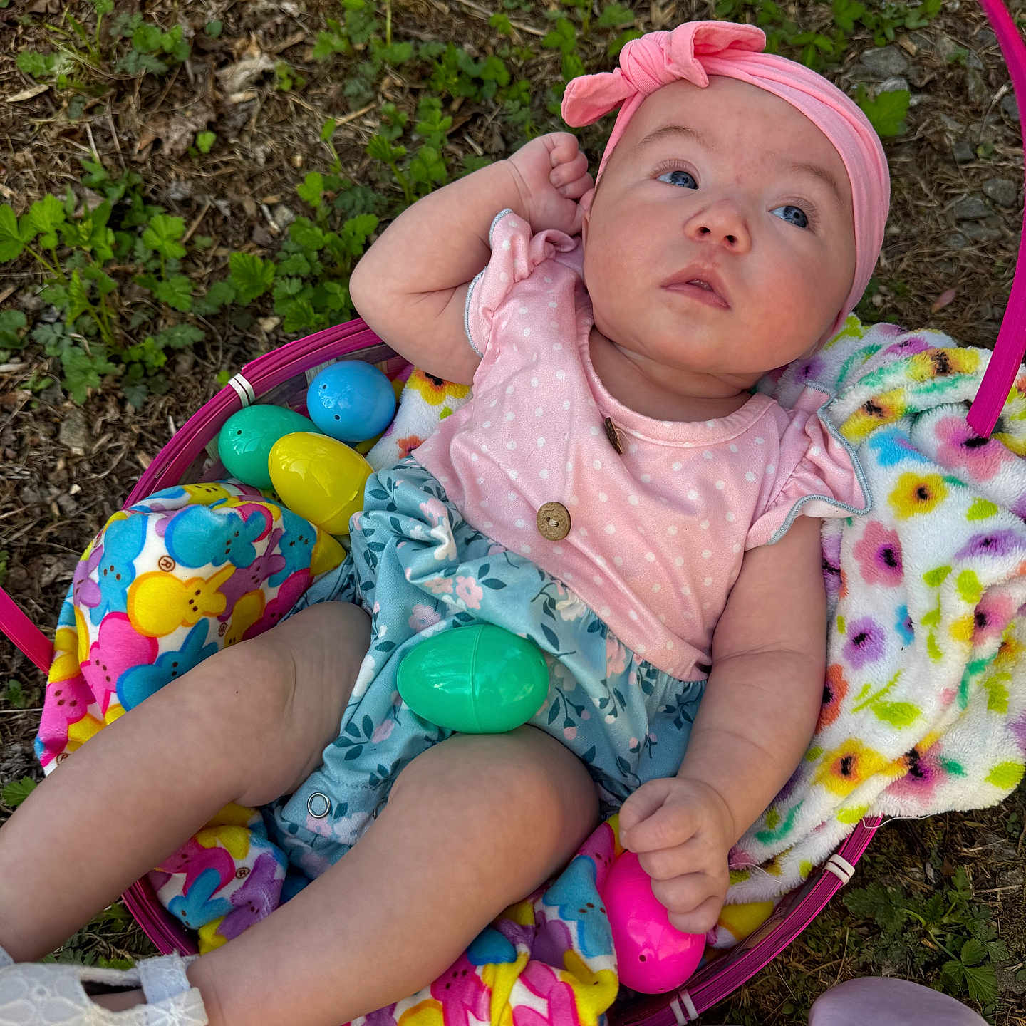 Aurora is registered to the contest to win money with this photo: baby, blanket, blue_eyes, child, colorful, cute, easter_basket, easter_eggs, floral_pattern, grass, holiday, infant, nature, outdoor, person, pink_clothing, pink_headband, sitting, spring, white_shoes