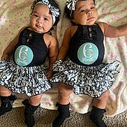 Amelie And Brielle is registered to the contest to win money with this photo: baby, twins, infant, six_months, headband, black_clothing, ruffled_skirt, socks, blanket, pink, butterfly_pattern, curly_hair, lying_down, carpet, cute, portrait, two_children, indoor, smiling, adorable