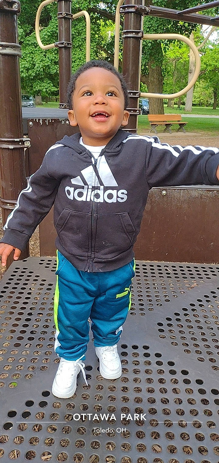 Arturo is registered to the contest to win money with this photo: baby, baby_toddler_clothing, child, cool, denim, electric_blue, fun, grass, happy, laugh, leisure, pattern, person, recreation, sleeve, smile, sneakers, t_shirt, toddler, tree