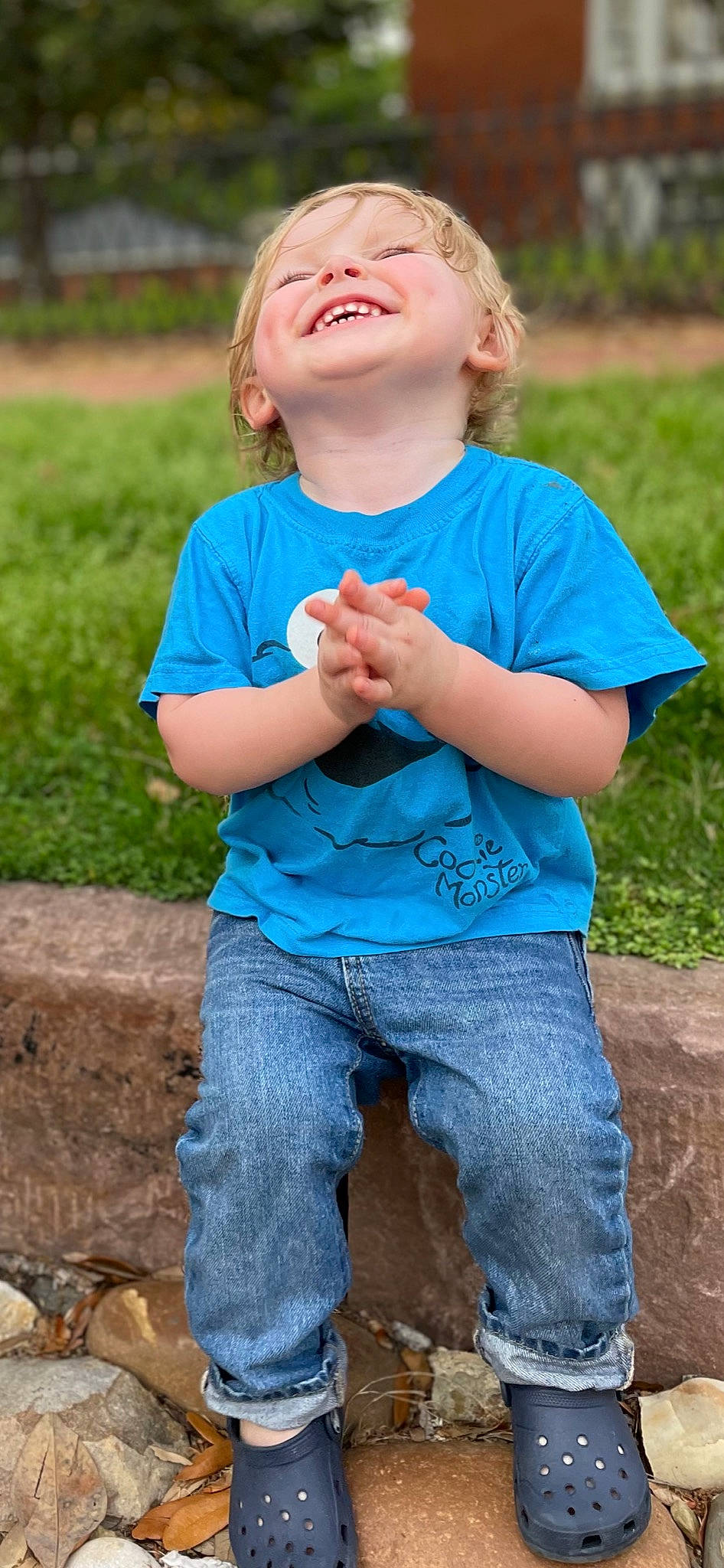 Jaxton is registered to the contest to win money with this photo: blue, face, facial_expression, finger, fruit, fun, gesture, grass, green, hand, happy, leisure, people_in_nature, person, photograph, plant, sleeve, summer, t_shirt, toddler