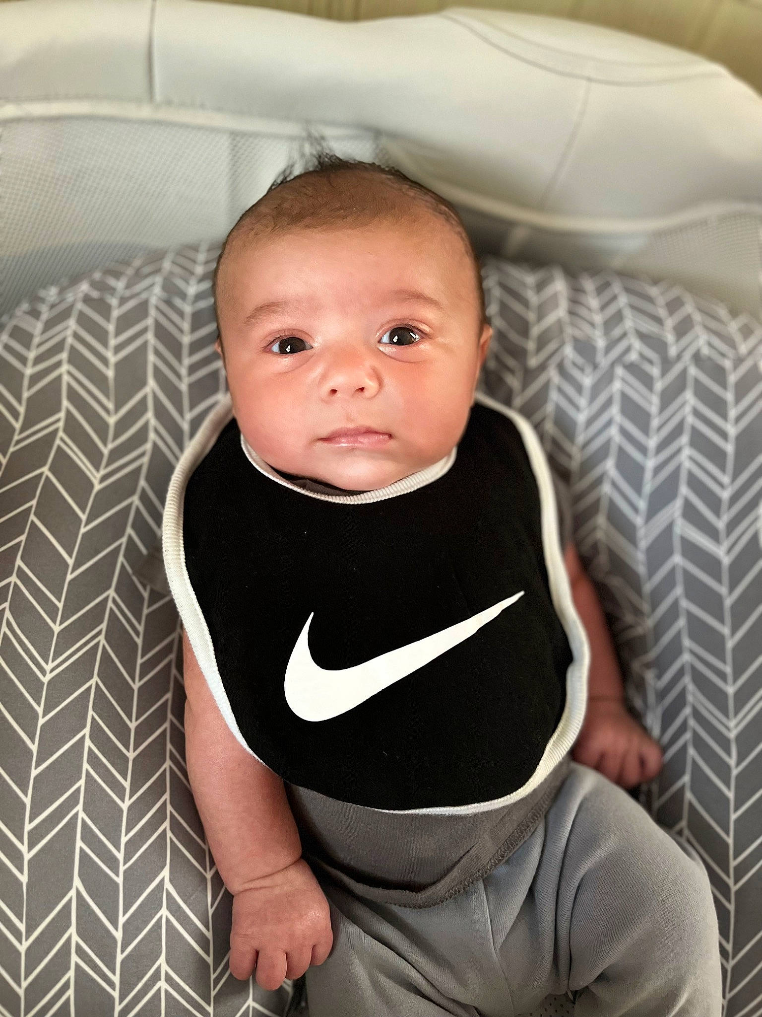 Dante is registered to the contest to win money with this photo: baby, baby_products, baby_toddler_clothing, chair, cheek, child, comfort, couch, elbow, happy, human_leg, knee, linens, pattern, person, room, sitting, sleeve, smile, toddler