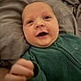 baby, infant, smiling, fleece, green_clothing, blanket, lying_down, face, hand, happy, closeup, child, cute, soft_texture, cozy, indoor, portrait, young, skin, expression