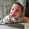 Sir' Hunter is registered to the contest to win money with this photo: baby, chewing, child, closeup, clothing, cushion, cute, face, hand, happy, high_chair, indoors, infant, person, polka_dot, portrait, seat, smiling, straps, young_child