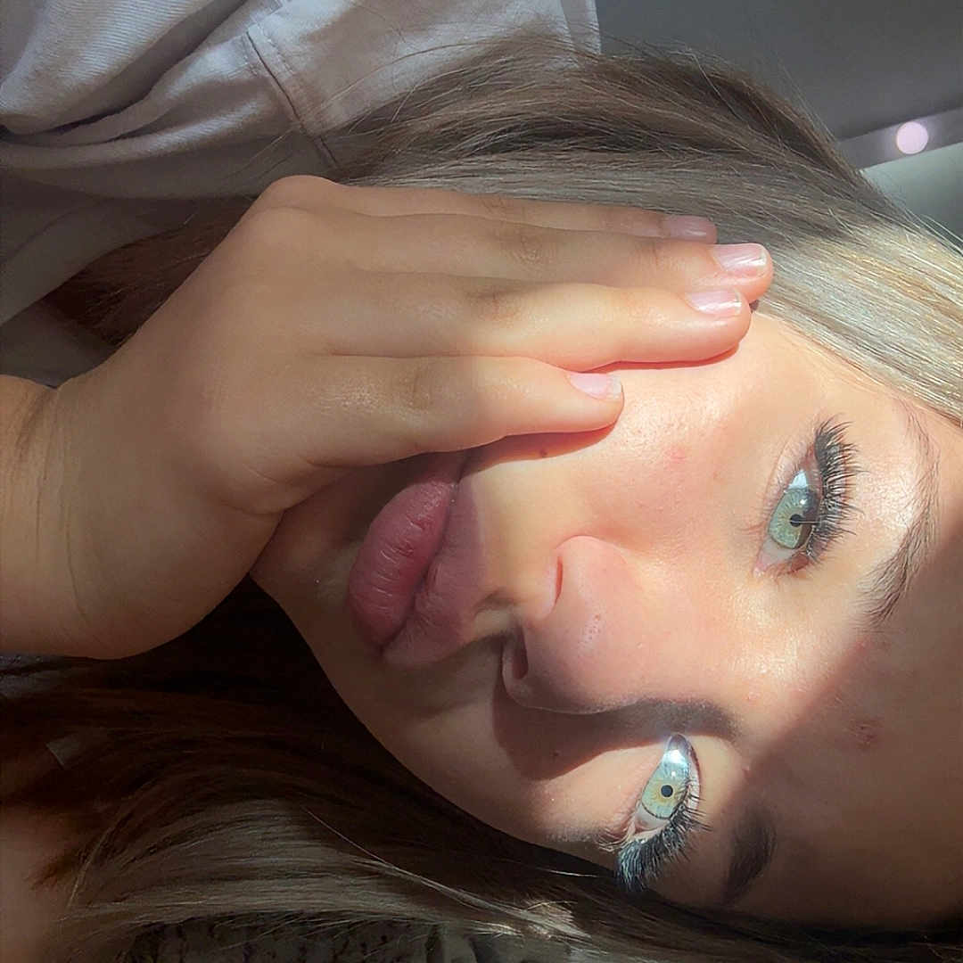 Lona a rejoint le concours — aidez-le/la à gagner de superbes lots ! person, face, hand, young_person, light_hair, eyelashes, skin, blanket, bed, shadow, casual_clothing, indoor, portrait, close_up, natural_light, relaxed, resting, sleepwear, comfort, home