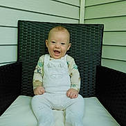 Ethan joined the competition — help win amazing prizes! baby, infant, smile, happy, sitting, chair, wicker, cushion, white_clothing, overalls, animal_design, face, hands, feet, porch, outdoor, wall_siding, child, cute, young