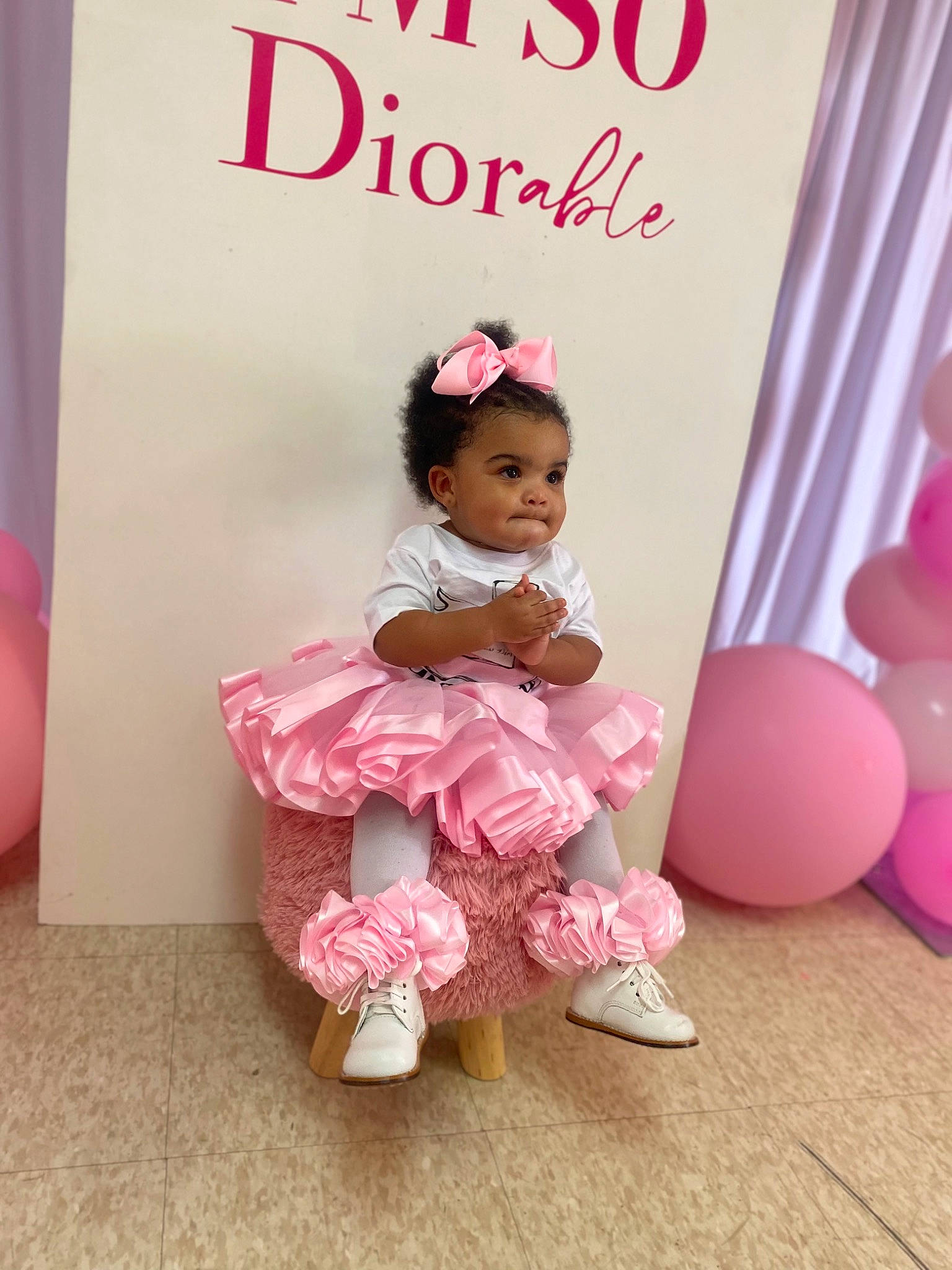 Ariyan is registered to the contest to win money with this photo: baby_toddler_clothing, balloon, child, event, face, flooring, font, happy, headpiece, magenta, party_supply, peach, person, petal, pink, room, ruffle, sitting, sweetness, toddler