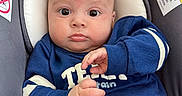 Kamil Izarra is registered to the contest to win money with this photo: baby, infant, child, car_seat, portrait, close_up, blue_clothing, sitting, indoors, face, eyes, hands, bald, alert, looking_at_camera, fabric, safety_label, automotive, photography, cute