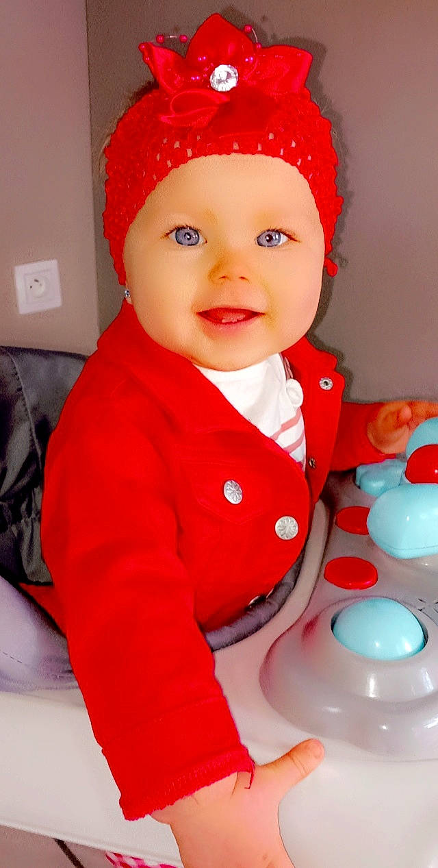 Anëlya participe au concours pour gagner de l'argent avec cette photo : baby, baby_toddler_clothing, beauty, cap, child, clothing, costume_hat, face, facial_expression, fun, happy, hat, organ, pink, red, skin, sleeve, smile, standing, toddler
