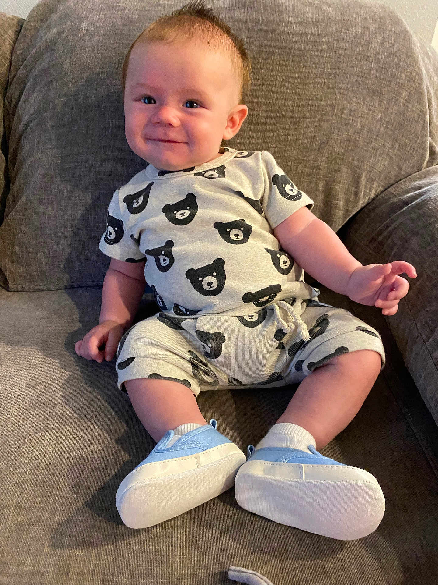 Weston is registered to the contest to win money with this photo: baby, child, smile, couch, clothing, bear_pattern, shoes, socks, indoor, furniture, happy, person, sitting, cute, infant, casual, young, portrait, cozy, relaxed