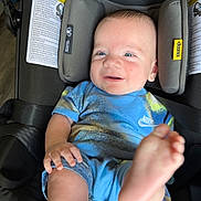 Silas is registered to the contest to win money with this photo: baby, child, car_seat, smile, happy, blue_clothing, nike, feet, infant, head_support, seat_belt, indoor, person, cute, young_child, playful, skin, face, hand, foot