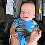 baby, child, car_seat, smile, happy, blue_clothing, nike, feet, infant, head_support, seat_belt, indoor, person, cute, young_child, playful, skin, face, hand, foot