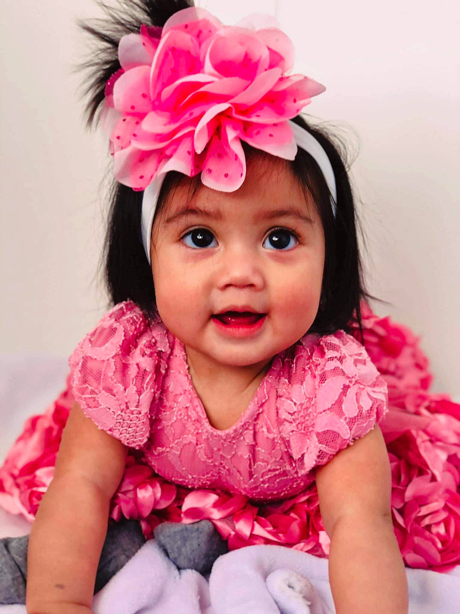 Aliyanna is registered to the contest to win money with this photo: baby, baby_toddler_clothing, dress, eye, eyelash, finger, fun, hairstyle, happy, hat, head, headpiece, headwear, lip, magenta, person, petal, pink, skin, sleeve