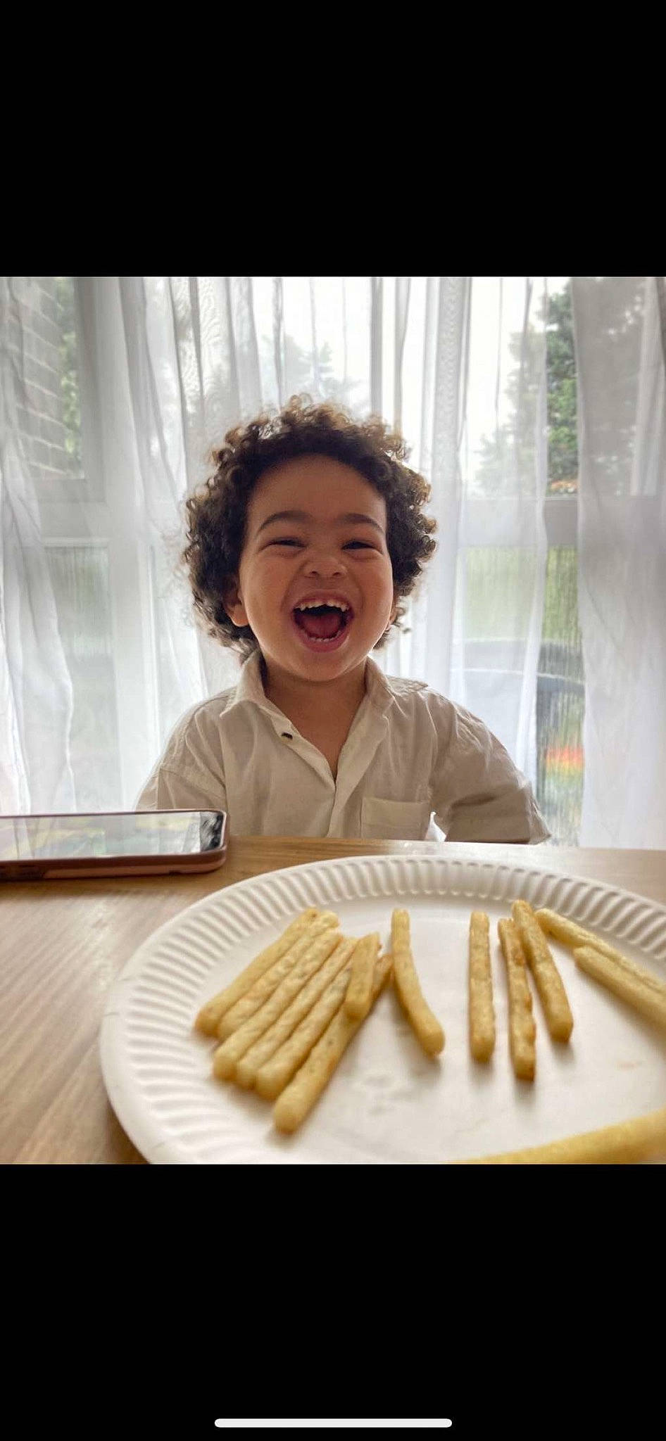 Ezra is registered to the contest to win money with this photo: comfort_food, cuisine, curtain, dish, finger, finger_food, food, food_craving, happy, ingredient, junk_food, person, plate, recipe, sharing, smile, staple_food, table, tableware, toddler