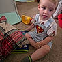 Sawyer is registered to the contest to win money with this photo: toddler, child, superman_logo, carpet, toy, sock, indoor, plaid_blanket, yellow_toy, bucket, clothing, person, floor, furniture, home, shorts, shirt, light_blond_hair, sitting, curious